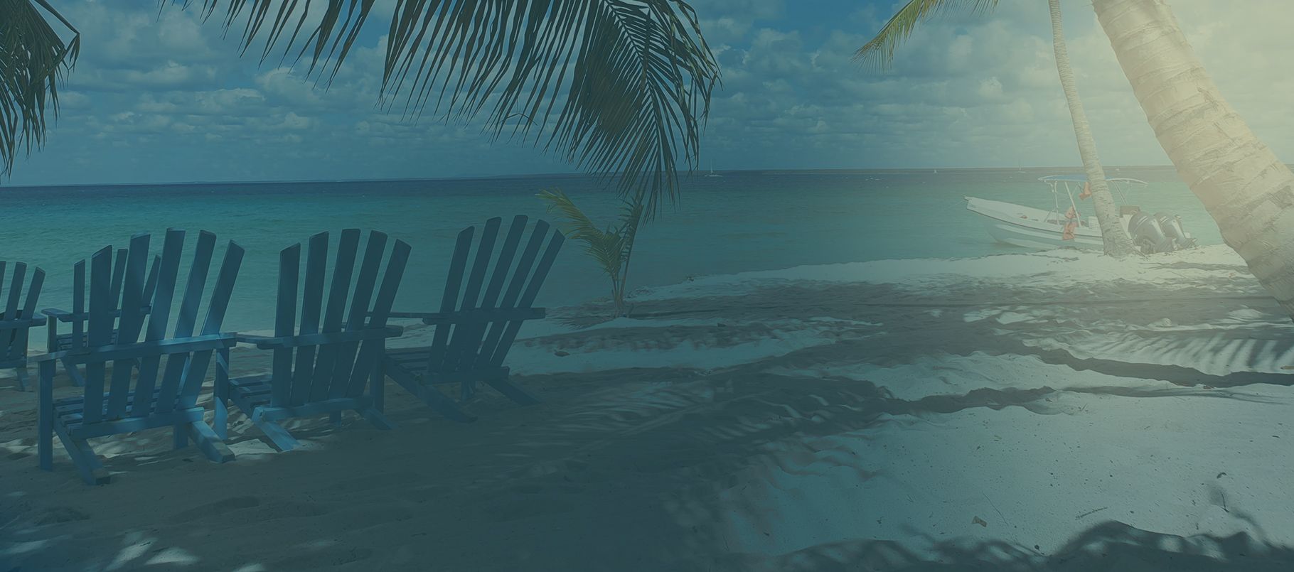 Adirondack chairs facing the ocean on a New Smyrna Beach shoreline, with a boat anchored near the palms