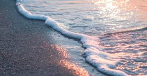 Gentle surf washing over the sand at sunrise on the New Smyrna Beach shoreline